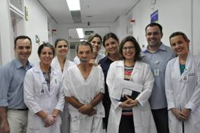Paciente Danúbio, ladeado pela equipe multidisciplinar do Proface, formada por profissionais da Fonoaudiologia, Fisioterapia, Nutrição, Psicologia, Assistência Social, Enfermagem e médicos