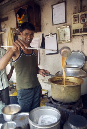 Homem prepara chai masala, em Mumbai