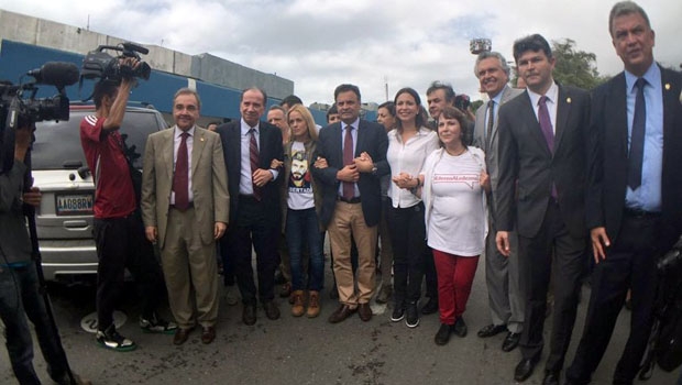 Senadores Agripino Maia, Aloysio Nunes Ferreira, Aécio Neves, Ronaldo Caiado, José Medeiros e Sérgio Petecão com esposas de presos políticos na Venezuela, antes do embarque em ônibus que foi bloqueado por manifestantes |Reprodução/Twitter