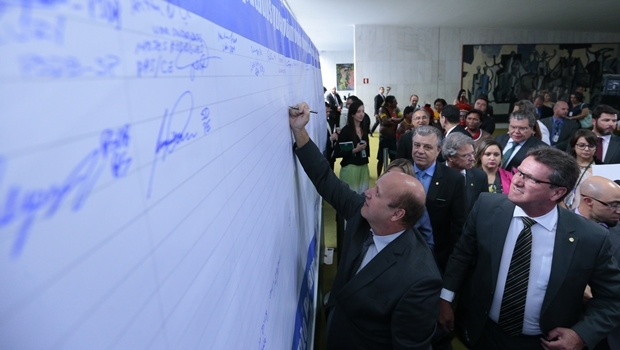 Célio Silveira assinando o painel | Foto: Alexssandro Loyola 