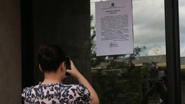 Cartaz colado em edifício na UNB informa aos inscritos no ENEM que fariam a prova no local, de seu adiamento para os dias 3 e 4 de Dezembro. (Fabio Rodrigues Pozzebom/Agência Brasil)