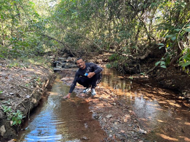 Repórter Nielton Soares dos Santos aferindo as águas do córrego de Niquelândia | Foto: Uarian Ferreira