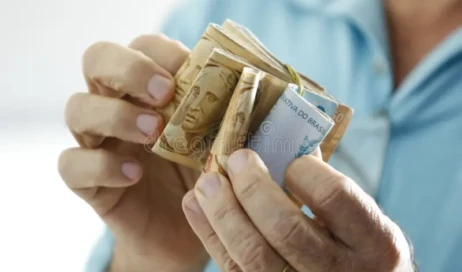 mãos-com-notas-verdadeiras-brasileiras-moeda-do-brasil-real-dinheiro-brl-brasileira-economia-renda-e-negócios-159112525