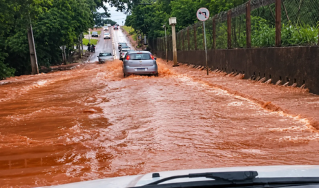 Alagamento urbano com carros na correnteza