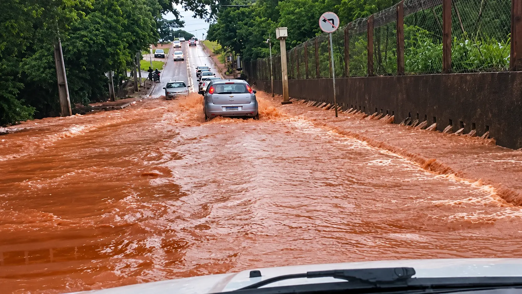 Alagamento urbano com carros na correnteza